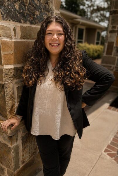 Bianca Bolden smiling outdoors in professional attire.