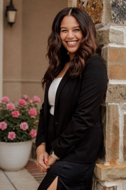 Keren Blanco smiling outdoors wearing black and white.