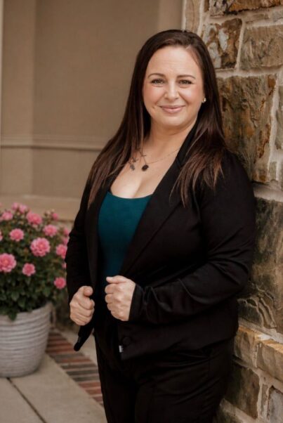 Jessica Hurd, standing in the entrance of a Village Green location, wearing blue and black.